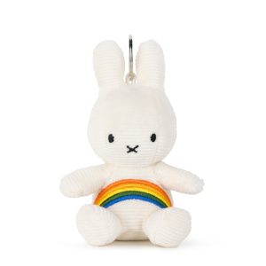 White plush Miffy toy seated upright against a plain white background, with a small rainbow-colored arc across its lap.