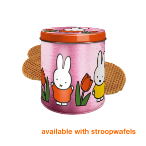 Cylindrical pink metal tin with an orange lid, decorated with illustrated white rabbit characters wearing orange and yellow outfits alongside orange tulips, with several round brown waffle cookies partially visible behind the tin.