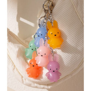 Set of three small pastel-colored Miffy figurines in pink, yellow, and blue, stacked in a hand.