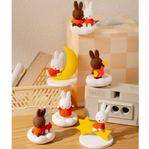 Small white shelf displaying Miffy-themed ceramic figurines and accessories in soft pastel colors.