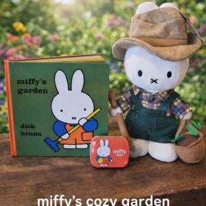 Miffy plush toy seated outdoors, wearing a beige hat and green outfit, displayed next to a green illustrated book and a small pink accessory.