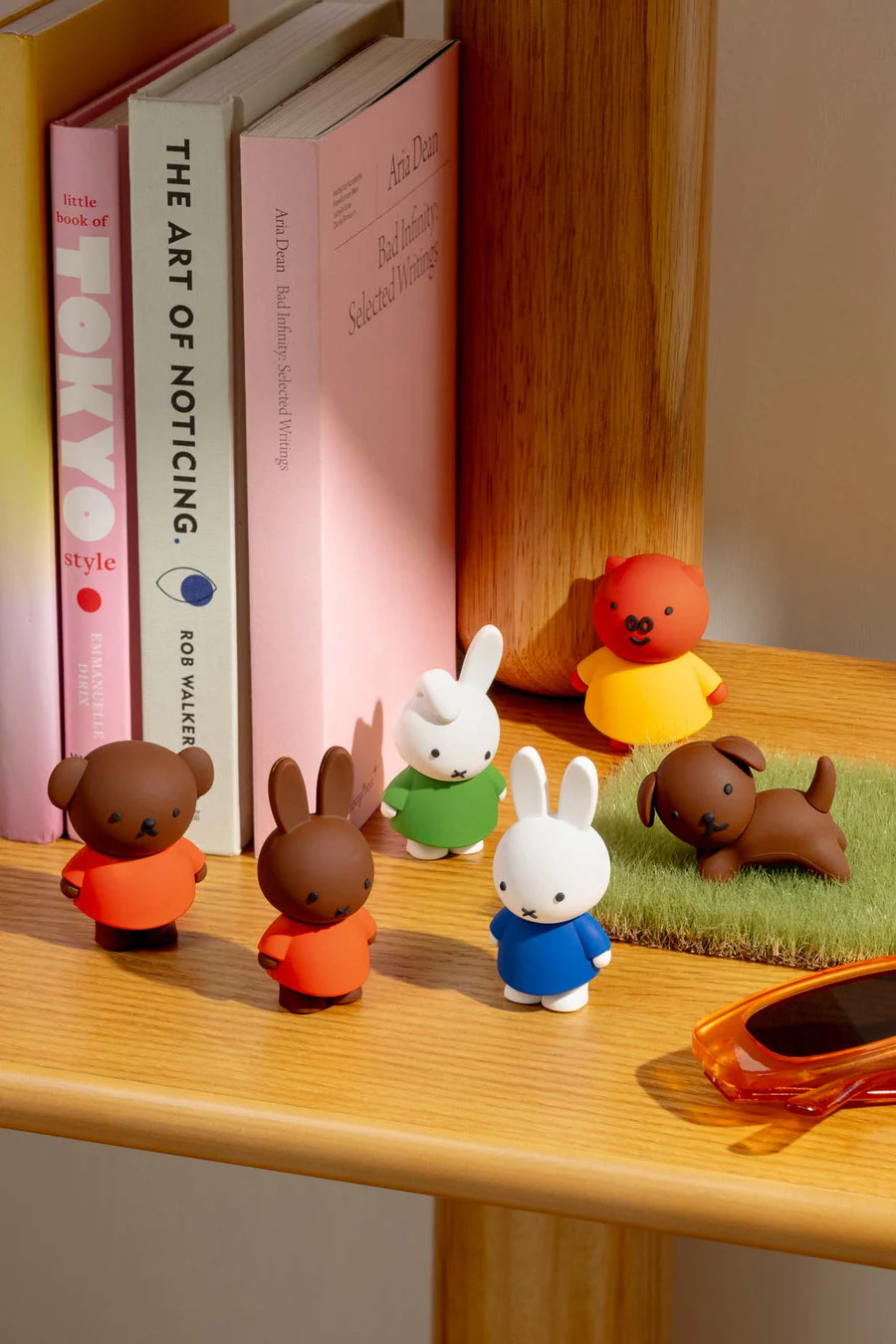 Miffy and friendsfigures on a shelf with books.