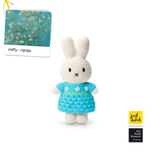Knitted white Miffy rabbit in a blue dress with a white floral print.