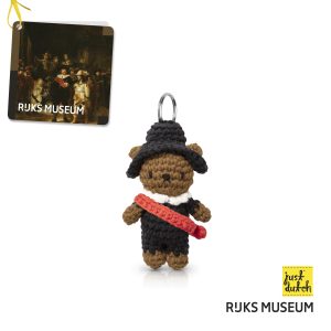 Knitted brown bear keychain in a black outfit and hat with a red scarf.
