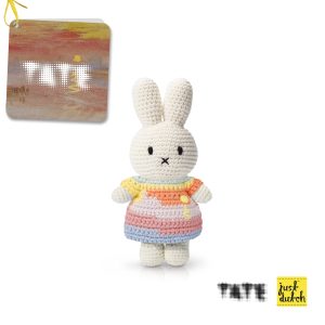 Knitted white knitted rabbit in a multi-colored dress with a small floral pattern.