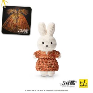 Knitted white Miffy rabbit in a brown patterned dress.