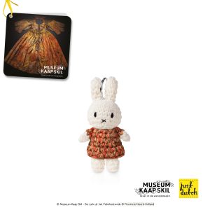 Knitted white Miffy rabbit keychain in a brown patterned dress.