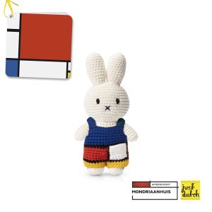 Knitted white Miffy rabbit in a blue overall decorated with a geometric color-block pattern of red, white, and yellow rectangles separated by black lines.