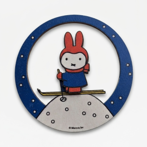Round wooden magnet featuring a white Miffy rabbit dressed in a winter outfit with a scarf and hat on a light background.