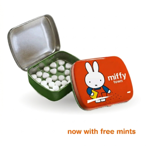 Small open metal tin with a green interior shown next to a closed orange tin, both featuring Miffy illustrations.